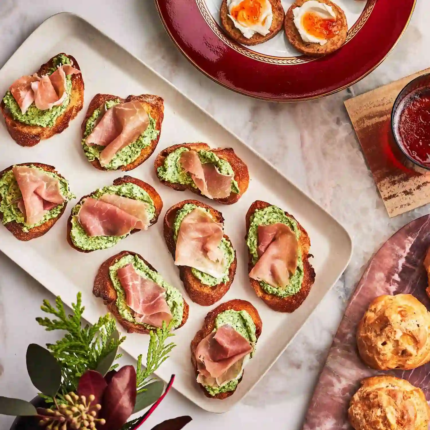 Crispy crostini topped with creamy herb spread and premium prosciutto appetizer.