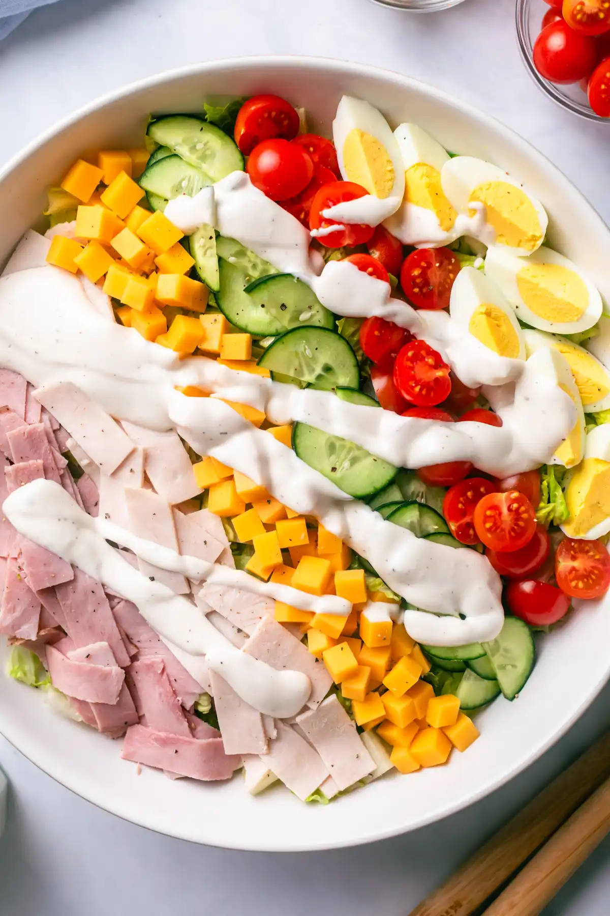 Fresh chef salad with turkey, ham, cheese, cucumber, tomatoes, eggs, and creamy dressing, perfect for anyone searching for salads. salads near me