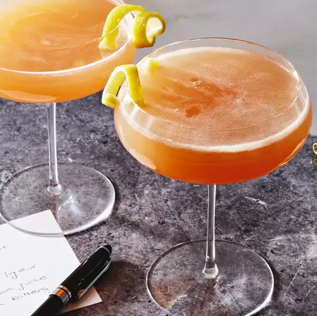 Refreshing signature cocktail served with a lemon twist in an elegant glass restaurant near vadakara.